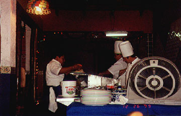 The chefs prepare dinner at the grill inside the front door at La Mision